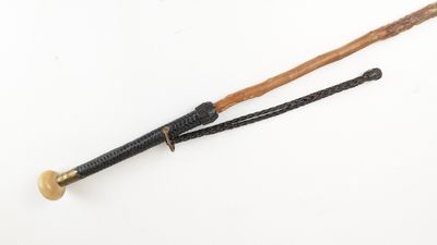 an old cane with a wooden handle on a white surface