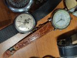 many different types of watches sitting on a wooden table