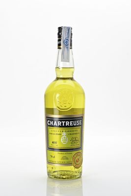 une bouteille de liqueur de citron à la Chartreuse posée sur une surface blanche