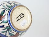 a close up of a vase on a white surface