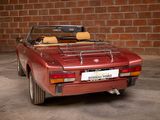 an image of a red convertible car parked in front of a brick wall