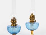 une paire de lampes en verre bleu montées sur des socles en métal doré, sur fond blanc