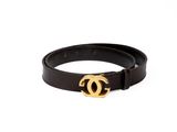 Gros plan sur une ceinture noire avec une boucle dorée