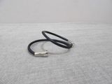 a black leather bracelet with a silver bar on it