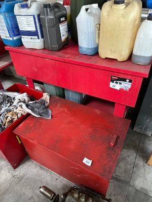 a red work bench with a lot of bottles of oil