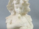 statue d'une petite fille tenant un oiseau dans ses mains