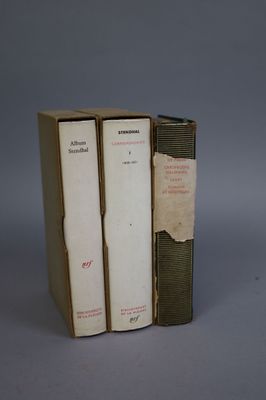 three books are stacked on top of each other on a gray surface
