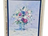tableau représentant un vase de fleurs posé sur une table, dans un cadre blanc