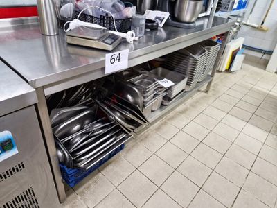 un plan de travail en acier inoxydable sur lequel sont posés des casseroles et des poêles, dans une cuisine professionnelle