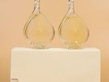 a pair of perfume bottles sitting on top of a white box