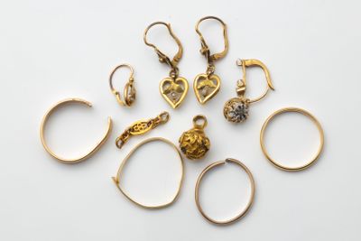un ensemble de bagues et de boucles d'oreilles en or posées sur une surface blanche