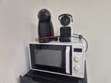 two microwaves on top of each other on a shelf