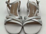 a close up of a pair of silver sandals on a white surface
