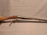 un vieux fusil avec une poignée en bois sur fond blanc