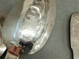 two spoons and a spoon rest on a table