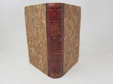 an old book sitting on top of a white surface