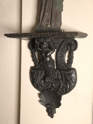 a wall sconce that has a statue on top of it