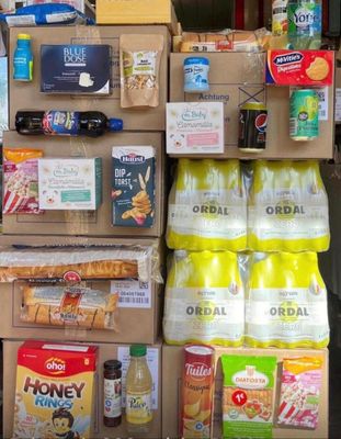 Des cartons de nourriture sont empilés les uns sur les autres devant un magasin