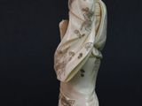 an image of a statue of a woman with a bird on her shoulder