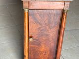 une armoire en bois avec un plateau en marbre, posée sur un sol carrelé