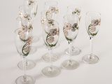 six wine glasses with flowers painted on them sitting on a white surface