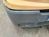 a dirty bumper of a car that is parked on the side of the road