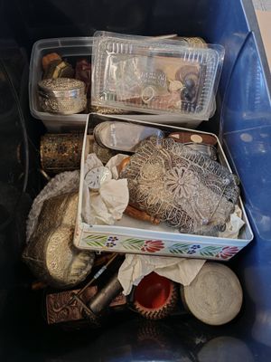 a blue bin filled with assorted items on the floor