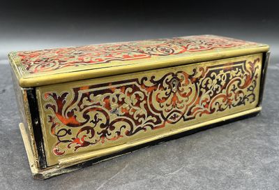 un coffret richement décoré, doré et rouge, posé sur une table