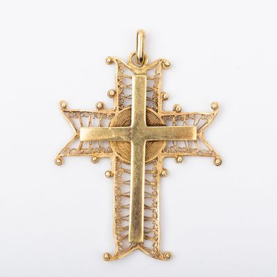 un pendentif en forme de croix dorée antique sur fond blanc