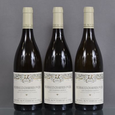 three bottles of wine are lined up on a table
