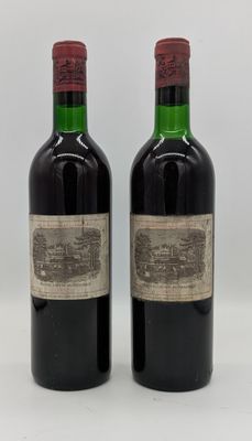 deux bouteilles de vin rouge posées l'une à côté de l'autre sur une surface blanche