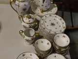une table blanche sur laquelle sont posés plusieurs assiettes et tasses