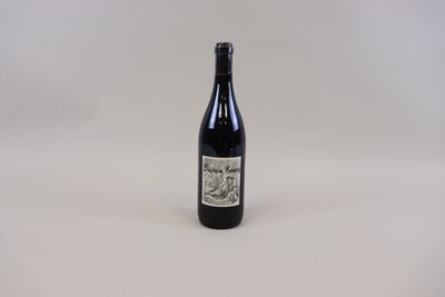 une bouteille de vin posée sur une table blanche