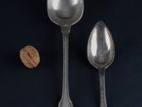 two spoons and a spoon with a walnut on a table