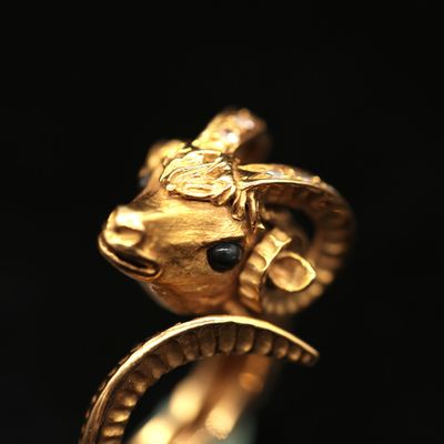 an image of a close up of a gold ring with a ram head on it