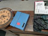 a table with a clock, drill, and other items on it