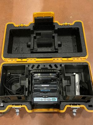 a yellow case with two batteries and a charger in it