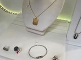 a display case with a necklace, bracelets, and other jewelry on it