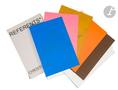 four different colored notebooks sitting on top of each other
