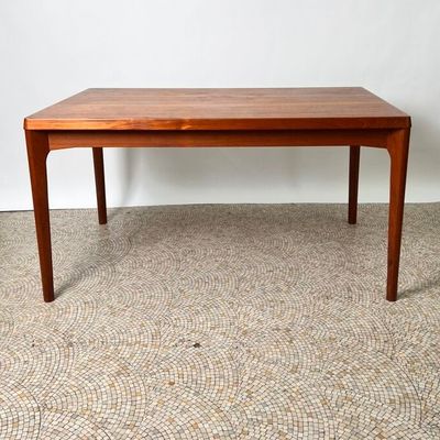 une photo d'une table en bois posée sur un sol recouvert de moquette