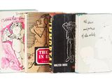Plusieurs livres sont empilés les uns sur les autres sur une surface blanche.