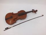 an old violin with a bow and bow rest on a white surface
