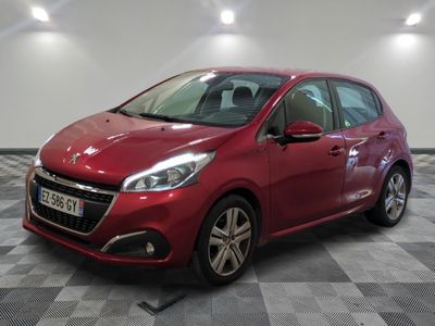une voiture rouge est garée dans une pièce au sol en damier