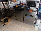 a kitchen with a lot of appliances and a lot of clutter on the counter