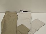 three pairs of pants and a cell phone on a table