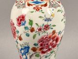 a vase with a lid that has flowers on it