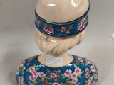 a figurine of a woman with a hat on her head