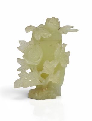 yellow jade carved vase with flowers and leaves on a stand