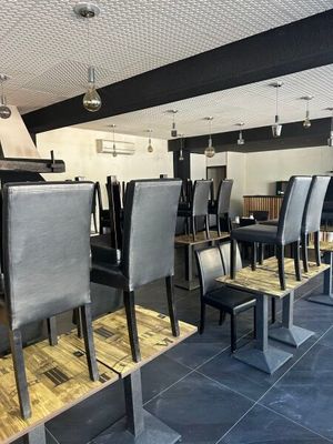 tables and chairs are lined up in a restaurant with a bar in the background