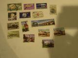 a shadow of a person standing in front of a wall with stamps on it